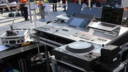 Großes DJ- und PA Equipment mit großem Mischpult und Laptopunterstützung auf einem Strassenfest.
