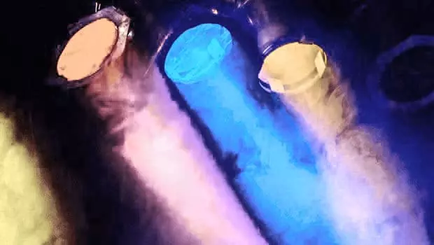 Drei farbige Scheinwerfer die durch Bühnennebel nach rechts unten strahlen.